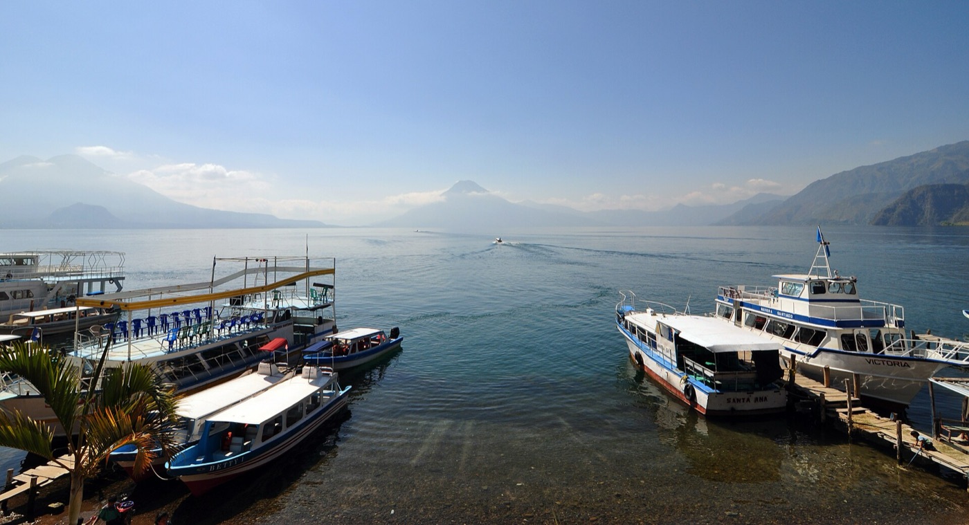 Lanchas en el muelle de Panajachel con los volcanes del Lago de Atitlán