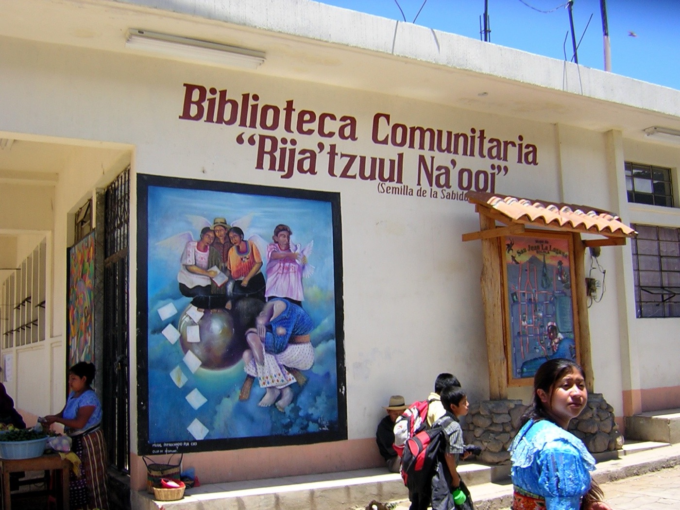 Mural y mujeres con traje típico en San Juan La Laguna, Atitlán